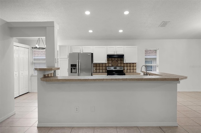 142 Stonegate Pass, Davenport, FL 33897 - kitchen with stainless steel fridge, electric range oven, range hood, white cabinetry, and light tile patterned flooring