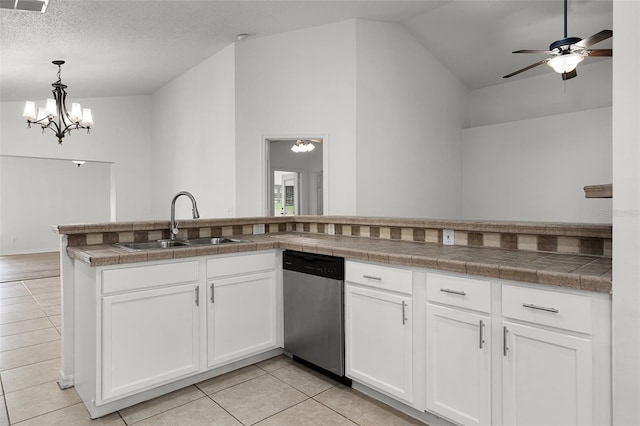 142 Stonegate Pass, Davenport, FL 33897 - kitchen featuring stainless steel dishwasher, a sink, light tile patterned floors, white cabinets, and vaulted ceiling