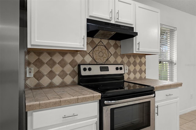 142 Stonegate Pass, Davenport, FL 33897 - kitchen with stainless steel electric stove, under cabinet range hood, and white cabinets