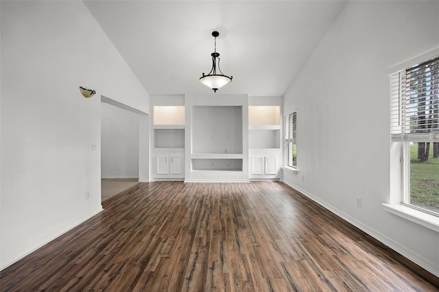 142 Stonegate Pass, Davenport, FL 33897 - unfurnished living room with built in features, baseboards, dark wood-style floors, and vaulted ceiling