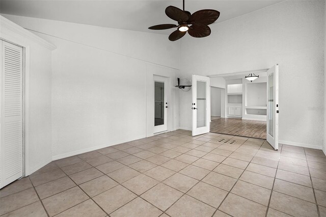 142 Stonegate Pass, Davenport, FL 33897 - spare room with light tile patterned floors, a ceiling fan, high vaulted ceiling, and baseboards