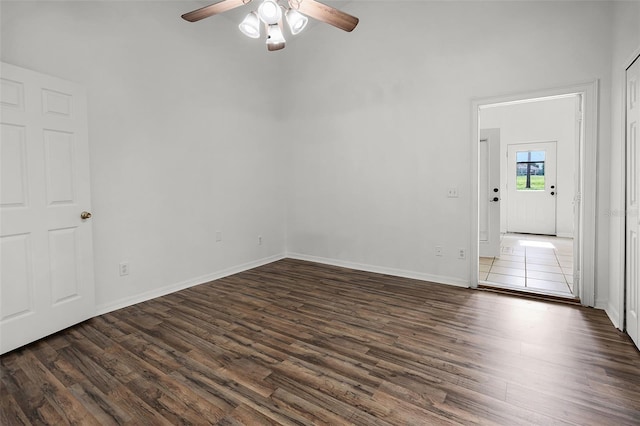 142 Stonegate Pass, Davenport, FL 33897 - spare room featuring dark wood-style flooring, ceiling fan, a towering ceiling, and baseboards