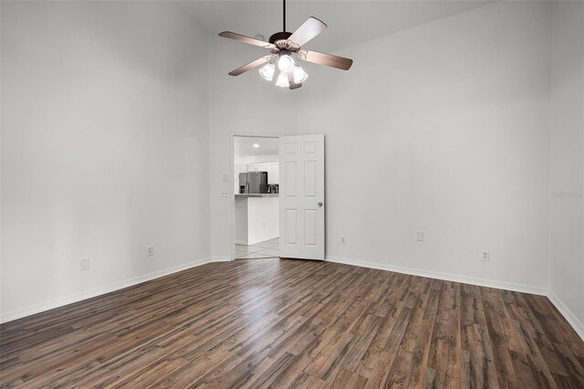 142 Stonegate Pass, Davenport, FL 33897 - unfurnished living room featuring dark wood-style floors, a towering ceiling, ceiling fan, and baseboards