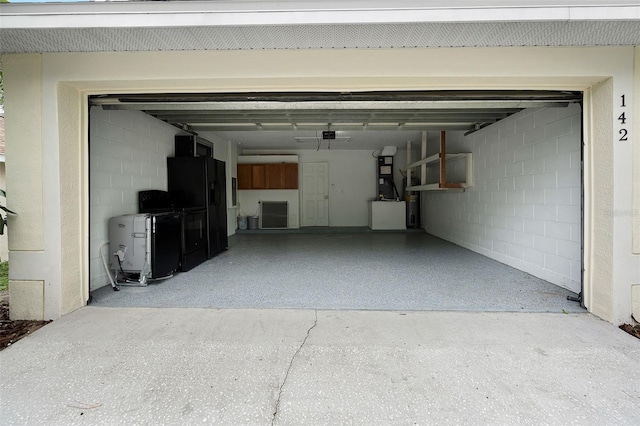 142 Stonegate Pass, Davenport, FL 33897 - garage featuring black refrigerator with ice dispenser and concrete block wall