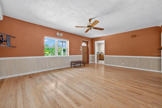 3637 Dubsdread Cir, Orlando, FL 32804 - empty room featuring hardwood / wood-style flooring, a textured ceiling, ceiling fan, and a wainscoted wall