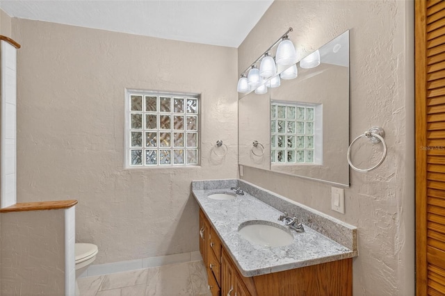 3637 Dubsdread Cir, Orlando, FL 32804 - bathroom with a textured wall, double vanity, toilet, baseboards, and a closet