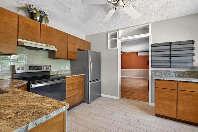 3637 Dubsdread Cir, Orlando, FL 32804 - kitchen with under cabinet range hood, stainless steel appliances, ceiling fan, brown cabinets, and a textured ceiling