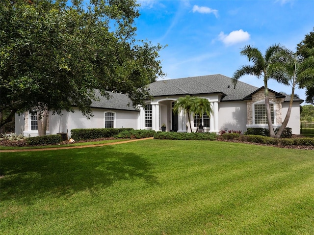 2106 Ridgewind Way, Windermere, FL 34786 - view of front of home featuring a front lawn, stone siding, stucco siding, and a shingled roof