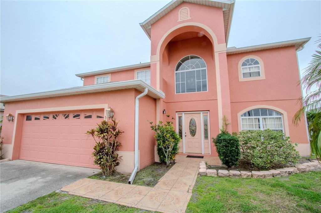 547 Brighton Ct, Kissimmee, FL 34758 - view of front facade with stucco siding, an attached garage, and driveway