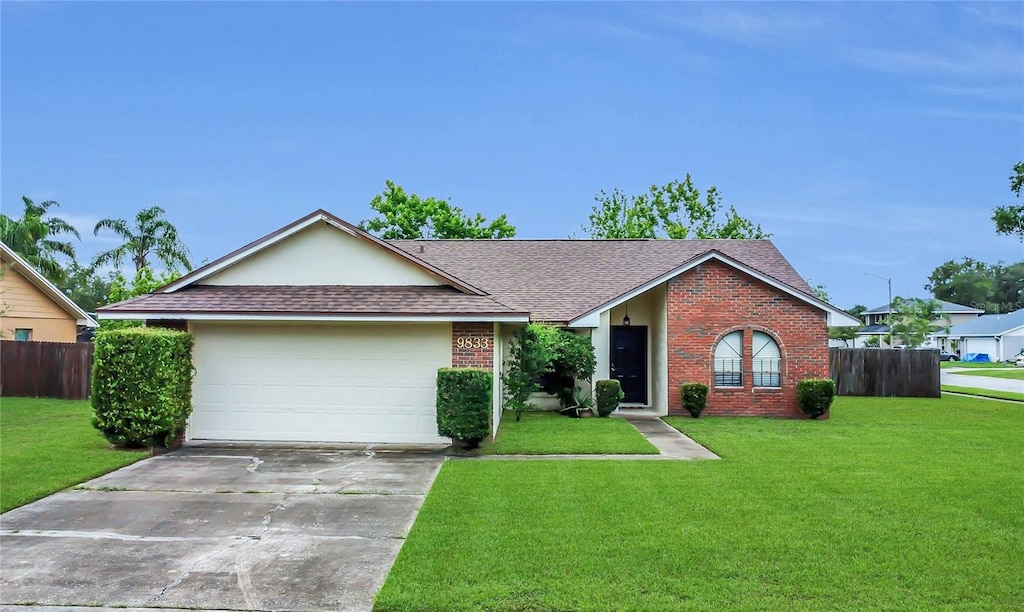 9833 Tattersall Ave, Orlando, FL 32817 - ranch-style house with brick siding, roof with shingles, driveway, and a garage