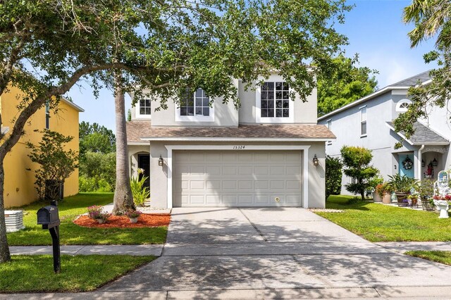 15324 Black Lion Way, Winter Garden, FL 34787 - view of front of home with stucco siding, a front yard, concrete driveway, and an attached garage