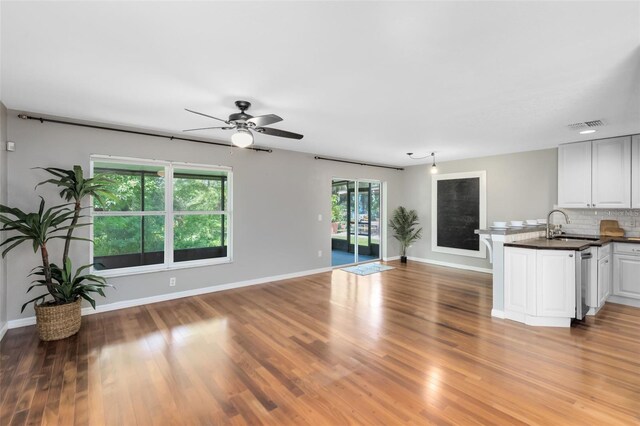 15324 Black Lion Way, Winter Garden, FL 34787 - unfurnished living room featuring light wood-type flooring, baseboards, a ceiling fan, and a sink