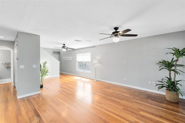 15324 Black Lion Way, Winter Garden, FL 34787 - unfurnished living room featuring ceiling fan, arched walkways, and baseboards