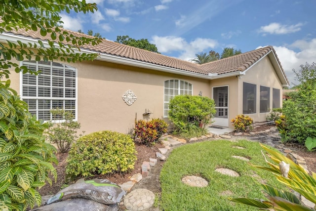 625 Nighthawk Cir, Winter Springs, FL 32708 - rear view of property with a tiled roof, stucco siding, and a sunroom