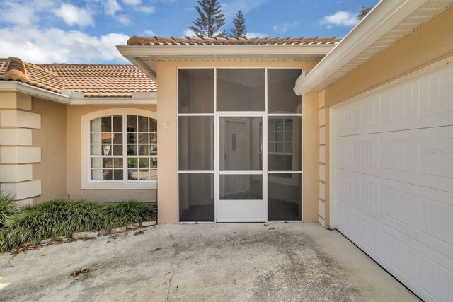 625 Nighthawk Cir, Winter Springs, FL 32708 - view of exterior entry with a tiled roof, stucco siding, and an attached garage