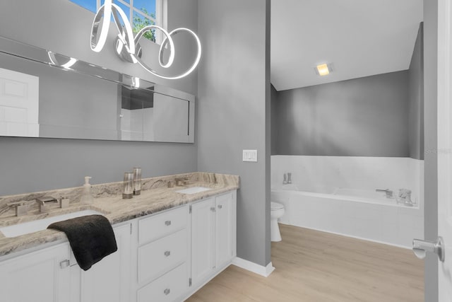 625 Nighthawk Cir, Winter Springs, FL 32708 - full bathroom with toilet, double vanity, a bath, wood finished floors, and baseboards
