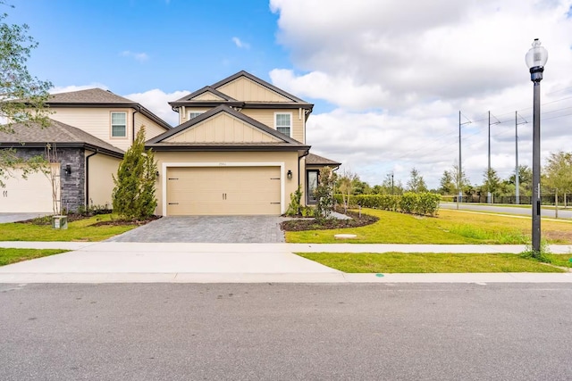 7951 Haverhill Way, Kissimmee, FL 34747 - view of front of property with board and batten siding, a front lawn, decorative driveway, and an attached garage