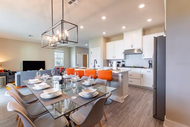 7951 Haverhill Way, Kissimmee, FL 34747 - dining space featuring light wood-type flooring, recessed lighting, and a chandelier