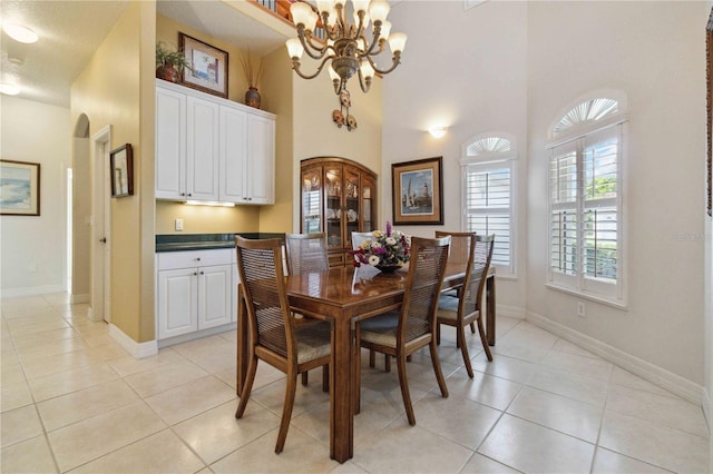 618 Manatee Bay Dr, Cape Canaveral, FL 32920 - dining area featuring a chandelier, light tile patterned flooring, and a towering ceiling