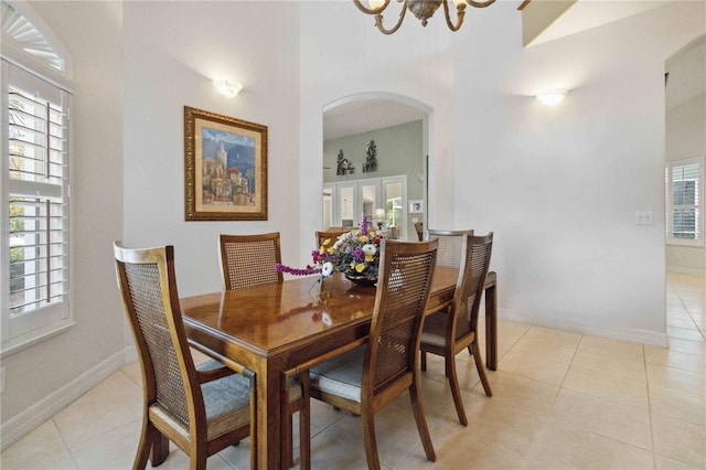 618 Manatee Bay Dr, Cape Canaveral, FL 32920 - dining space with arched walkways, a chandelier, healthy amount of natural light, and light tile patterned flooring