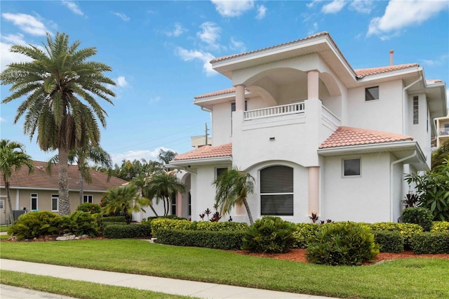 618 Manatee Bay Dr, Cape Canaveral, FL 32920 - mediterranean / spanish home with a tile roof, a balcony, stucco siding, and a front yard