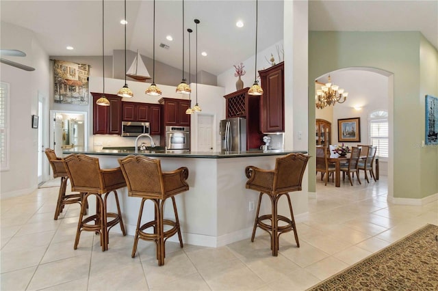 618 Manatee Bay Dr, Cape Canaveral, FL 32920 - kitchen featuring stainless steel appliances, arched walkways, high vaulted ceiling, dark countertops, and a breakfast bar area