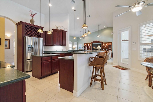 618 Manatee Bay Dr, Cape Canaveral, FL 32920 - kitchen featuring ceiling fan, stainless steel fridge, dark countertops, dark brown cabinets, and high vaulted ceiling