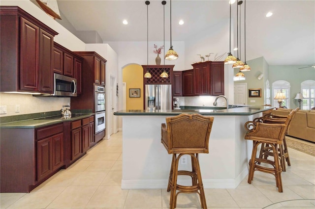 618 Manatee Bay Dr, Cape Canaveral, FL 32920 - kitchen featuring dark brown cabinets, stainless steel appliances, arched walkways, dark countertops, and recessed lighting