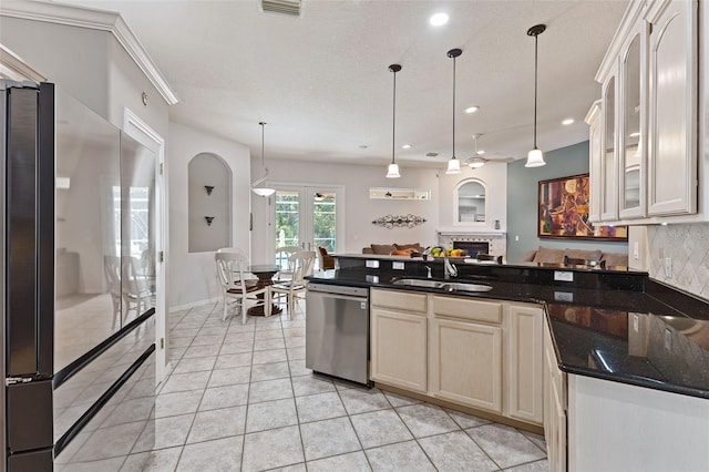 1907 Sir Lancelot Cir, Saint Cloud, FL 34772 - kitchen featuring appliances with stainless steel finishes, a sink, a peninsula, glass insert cabinets, and hanging light fixtures