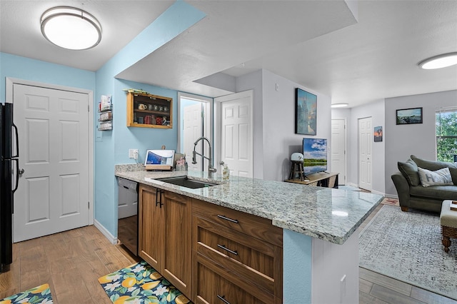 3028 Parkway Blvd Unit 308, Kissimmee, FL 34747 - kitchen with a sink, black appliances, light wood-style flooring, light stone countertops, and open floor plan