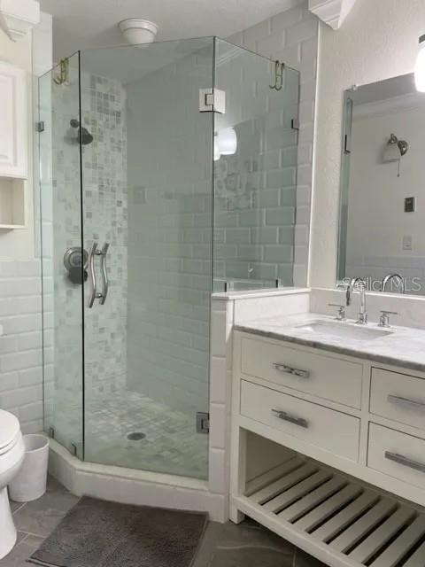 955 Gamewell Ave, Maitland, FL 32751 - bathroom featuring toilet, a stall shower, vanity, and tile patterned floors