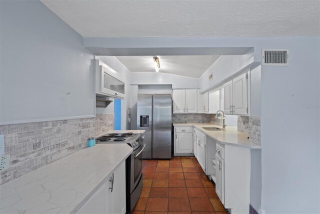 4420 Conway Gardens Rd, Orlando, FL 32806 - kitchen with appliances with stainless steel finishes, a sink, white cabinetry, backsplash, and vaulted ceiling