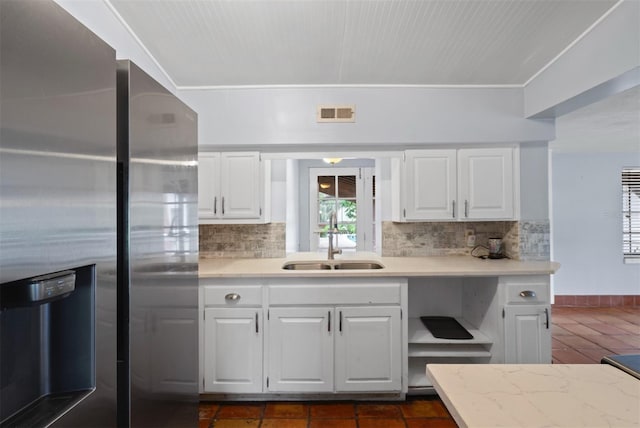 4420 Conway Gardens Rd, Orlando, FL 32806 - kitchen with stainless steel fridge with ice dispenser, a sink, decorative backsplash, and white cabinets