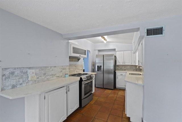 4420 Conway Gardens Rd, Orlando, FL 32806 - kitchen with appliances with stainless steel finishes, decorative backsplash, white cabinets, light countertops, and a textured ceiling