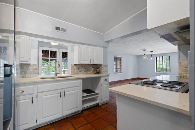 4420 Conway Gardens Rd, Orlando, FL 32806 - kitchen featuring a sink, electric stovetop, tasteful backsplash, white cabinets, and vaulted ceiling