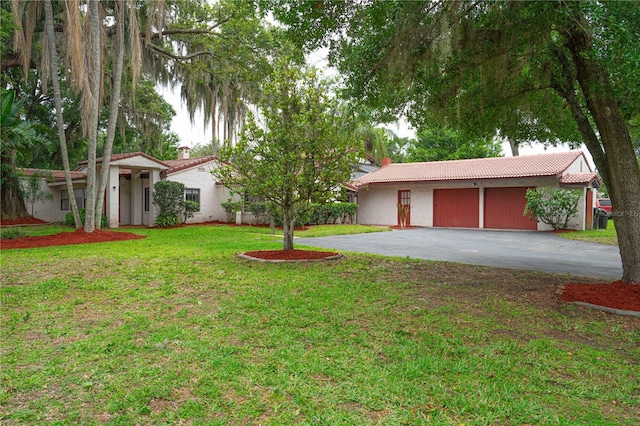 4420 Conway Gardens Rd, Orlando, FL 32806 - view of front of house with asphalt driveway, a tile roof, a front lawn, a chimney, and stucco siding