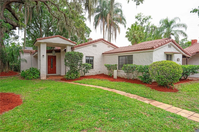 4420 Conway Gardens Rd, Orlando, FL 32806 - mediterranean / spanish-style home with a tile roof, a front yard, and stucco siding