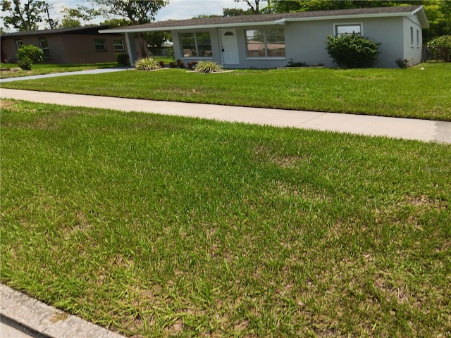 2103 Mantilla Ave, Orlando, FL 32811 - ranch-style home featuring a front yard, stucco siding, a carport, and driveway
