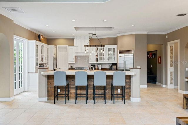 2357 Alaqua Dr, Longwood, FL 32779 - kitchen featuring built in refrigerator, tasteful backsplash, white cabinets, glass insert cabinets, and light countertops