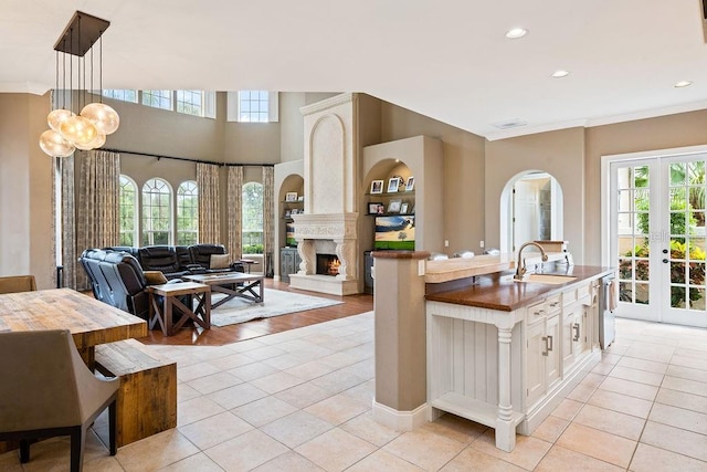 2357 Alaqua Dr, Longwood, FL 32779 - kitchen featuring a sink, healthy amount of natural light, light tile patterned floors, open floor plan, and crown molding