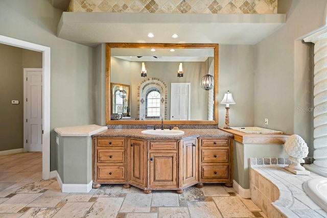 2357 Alaqua Dr, Longwood, FL 32779 - bathroom with stone tile floors, vanity, baseboards, a bath, and recessed lighting