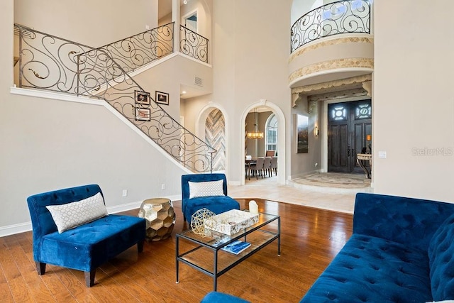 2357 Alaqua Dr, Longwood, FL 32779 - living area with stairs, arched walkways, wood finished floors, baseboards, and a towering ceiling