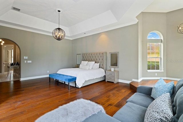 2357 Alaqua Dr, Longwood, FL 32779 - bedroom with a chandelier, a raised ceiling, arched walkways, hardwood / wood-style floors, and baseboards
