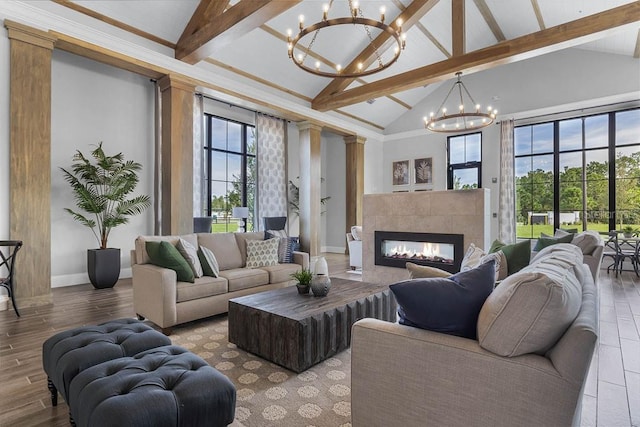living area with a chandelier, beam ceiling, baseboards, wood finished floors, and a fireplace