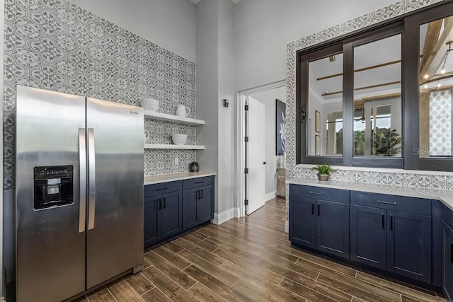kitchen with stainless steel fridge with ice dispenser, light countertops, tasteful backsplash, dark wood finished floors, and open shelves