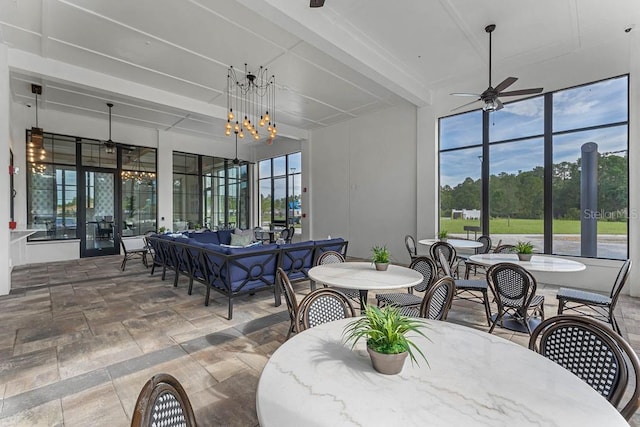 sunroom / solarium with beamed ceiling and a chandelier