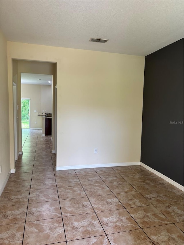 11187 Savannah Landing Cir, Orlando, FL 32832 - spare room featuring a textured ceiling, light tile patterned floors, and baseboards