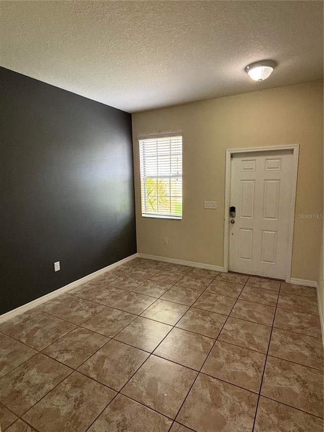 11187 Savannah Landing Cir, Orlando, FL 32832 - foyer with a textured ceiling, light tile patterned flooring, and baseboards