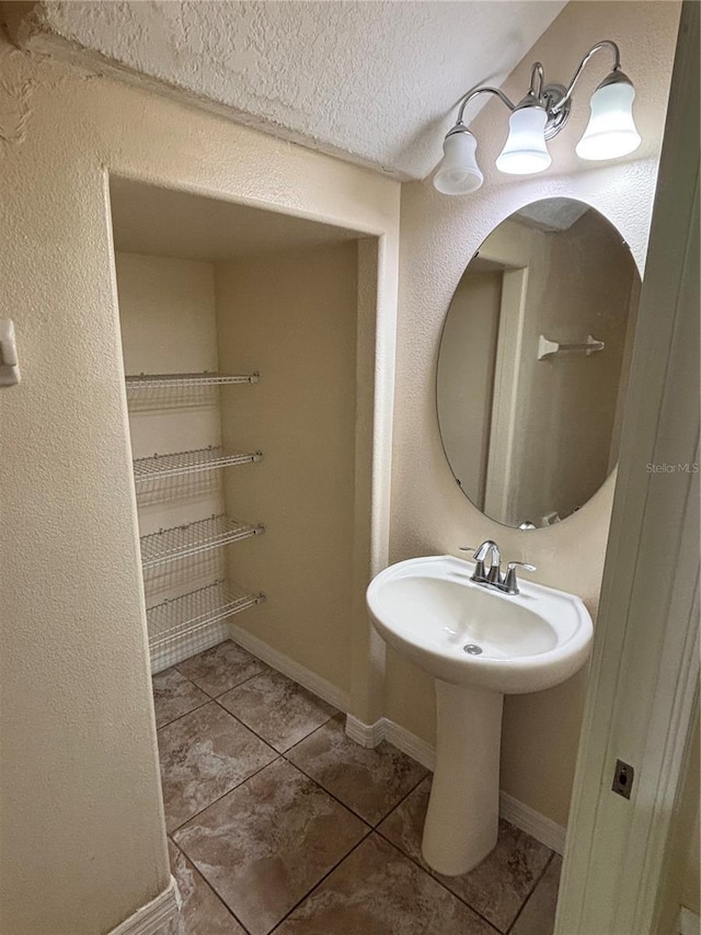 11187 Savannah Landing Cir, Orlando, FL 32832 - bathroom featuring tile patterned flooring, baseboards, a sink, and a textured ceiling
