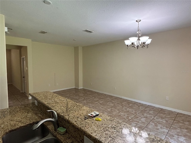 11187 Savannah Landing Cir, Orlando, FL 32832 - kitchen featuring tile patterned flooring, a chandelier, a sink, decorative light fixtures, and a textured ceiling